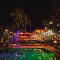Finca iluminada de noche junto a la alberca